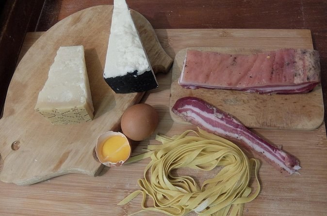Pecorino, guanciale, an egg yolk and fresh pasta, laid out on a board