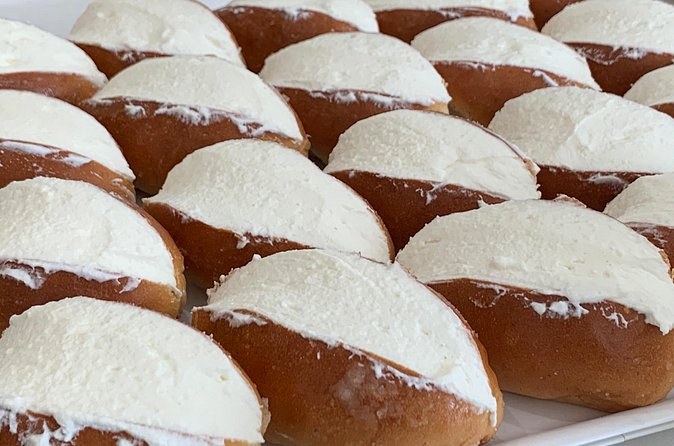 Maritozzi split and filled with whipped cream, tray after tray