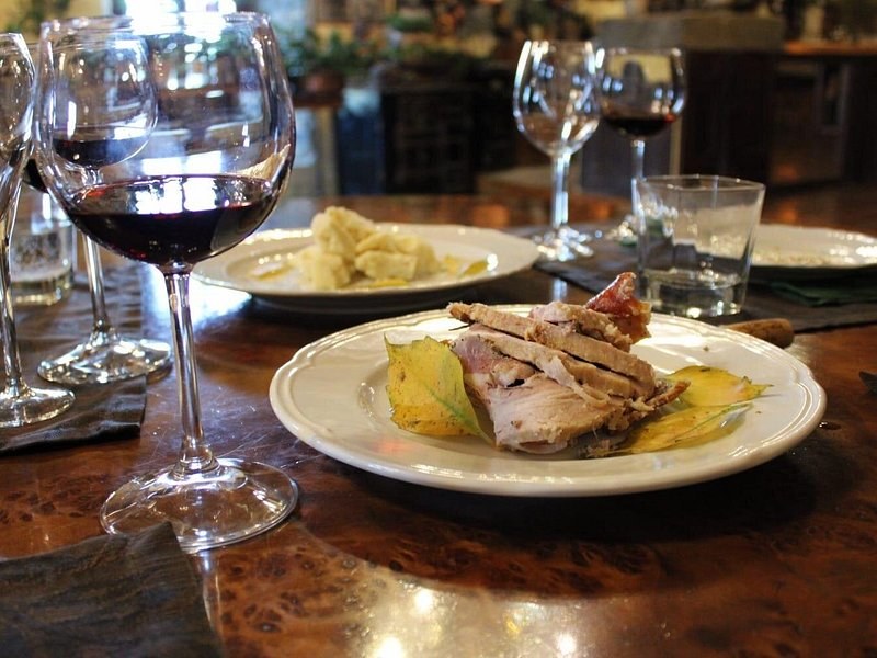 A plate of Roman cooking and a glass of red on a trattoria table