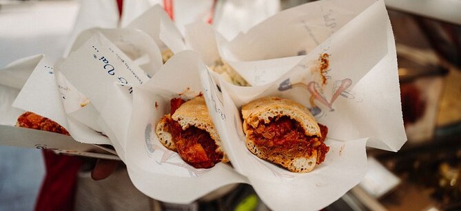 Supplì handed out in paper wrappers at a street-food stop